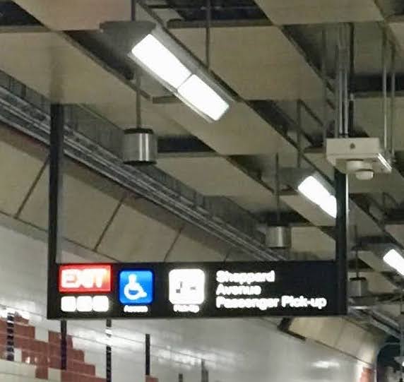 Don Mills mezzanine with lots of visual stimuli and sign that reads (in part): "EXIT Sheppard/ Avenue/ Passenger Pick-up".