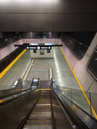 Coming down escalator with "← Northbound (1) Southbound →" sign overhead.